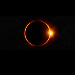 A solar eclipse with the edges of the sun visible in the darkness